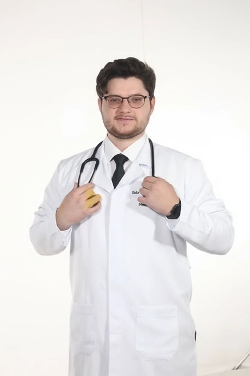 Dr. Gabriel De Marco, jaleco branco, mãos no bolso do jaleco